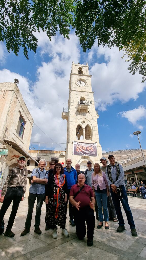 Group of visitors to Nablus standing in front of its clock tower